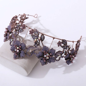 Macro view of purple floral tiara with crystal rhinestones on a grey display stand