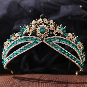 Detailed macro view of luxury gold bridal crown with emerald green rhinestones