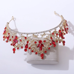 Détail d'une couronne de mariée dorée avec gemmes rouges et motifs de vigne