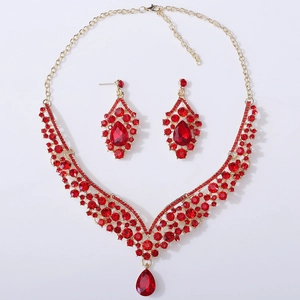 Detailed macro view of bridal jewelry set with red teardrop crystals and gold finish
