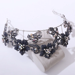 Vintage baroque tiara with purple floral rhinestones on a grey velvet display pillow