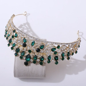 Detail of vintage gold bridal crown with emerald green gems and sparkling rhinestones