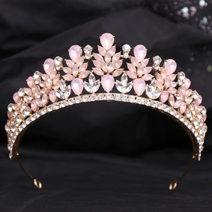 Close-up of golden alloy tiara featuring pink teardrop crystals and sparkling rhinestones