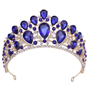 Detail view of luxurious gold crown with pear-shaped blue gemstones and white crystals