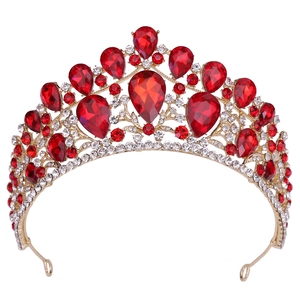 Macro detail of luxury gold bridal tiara featuring large red pear-cut gems and rhinestones