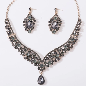 Detailed flat lay of bridal jewelry set with grey teardrop crystals in antique gold
