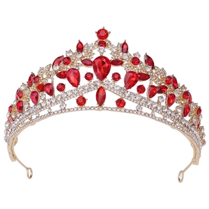 Close-up of gold bridal crown with large pear-cut red rubies and sparkling white rhinestones