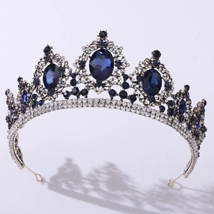 Detail view of Baroque crown featuring large blue gemstones and silver filigree with rhinestones