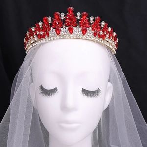 Vintage bridal tiara with red crystals and gold alloy leaves on a white wedding veil