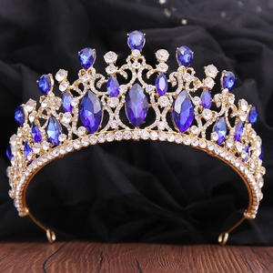 Detailed macro view of baroque gold tiara with blue gemstones and clear crystals