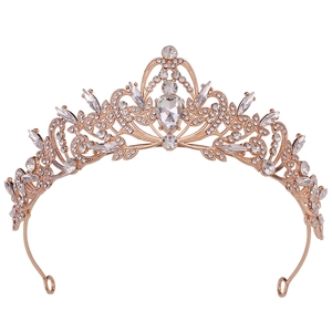 Close-up of rose gold bridal crown with crystal teardrop and intricate rhinestone leaves