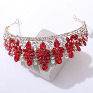 Close-up of golden bridal tiara with red teardrop rhinestones and sparkling leaf details