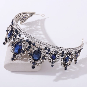 Detailed close-up of vintage silver tiara with deep blue gemstones and crystal rhinestones