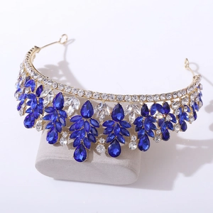 Close-up of golden alloy crown with blue teardrop crystals and white marquise zircons