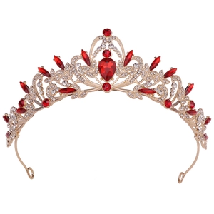Close-up of golden bridal crown featuring red pear-shaped gems and white rhinestones