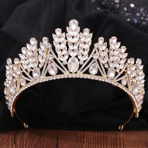 Détail d'une couronne de mariée dorée sertie de strass brillants sur dentelle noire