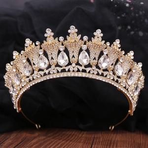 Macro detail of luxury gold bridal crown with shimmering crystals on dark wood background