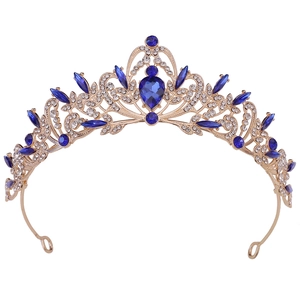 Detail of vintage golden bridal crown with blue teardrop gemstone and leaf pattern