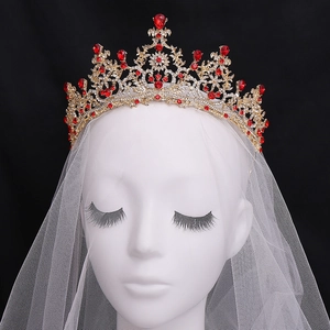 Exquisite goldene Brautkrone mit roten Strasssteinen und weißem Schleier auf einem Mannequin