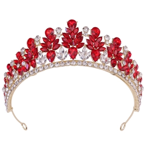 Close-up of golden alloy bridal crown featuring pear-cut red and white rhinestones