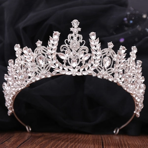 Macro shot of intricate silver bridal crown with crystals on dark velvet backdrop