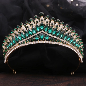 Detailed close-up of emerald and white crystal bridal crown with golden baroque metalwork