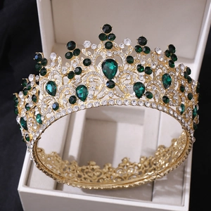 Détail de la couronne de mariée baroque dorée avec gemmes vertes et cristaux en coffret