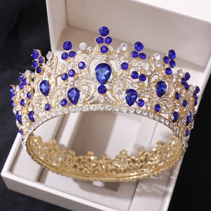 Détail d'une couronne baroque dorée avec gemmes bleu foncé et diamants dans un écrin cadeau