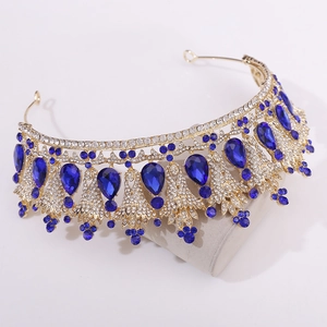 Detail view of gold bridal crown featuring teardrop blue crystals and white rhinestones
