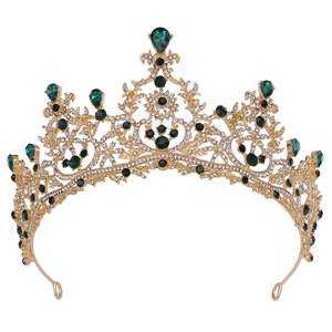 Detailansicht der goldenen Krone mit grünen Edelsteinen und klaren Schmucksteinen