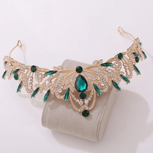 Detail of a vintage golden bridal tiara with emerald green stones and white rhinestones