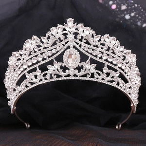 Elegant bridal tiara with silver rhinestones and central oval gem on dark backdrop