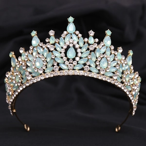 Close-up of gold bridal tiara with light blue teardrop rhinestones on black fabric