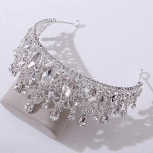Detailed close-up of a silver baroque crown with pear-cut crystals on velvet stand