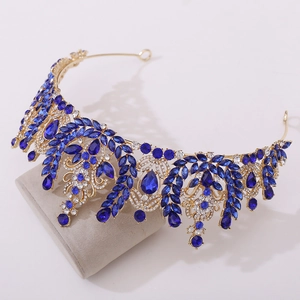 Close-up of golden crown with blue pear-shaped rhinestones and leaf-shaped metal base