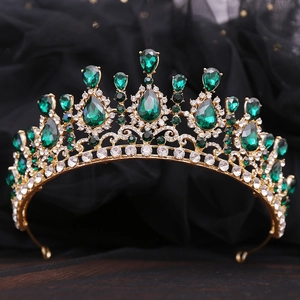 Dettaglio corona barocca dorata con cristalli a goccia verde smeraldo e strass luminosi