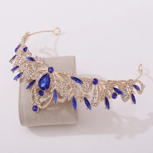Detailed macro view of golden leaf tiara with deep blue water drop gemstone and diamonds