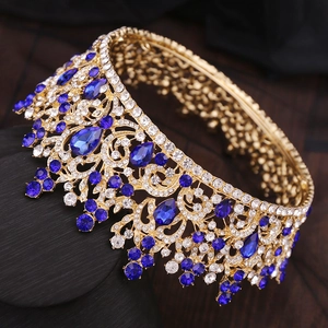 Détail d'une couronne de mariée baroque dorée avec strass blancs et cristaux bleu foncé