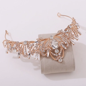Detailed macro view of rose gold leaf bridal crown with rhinestones on velvet stand