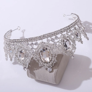Detail view of silver Baroque bridal crown with large oval crystals on a velvet stand