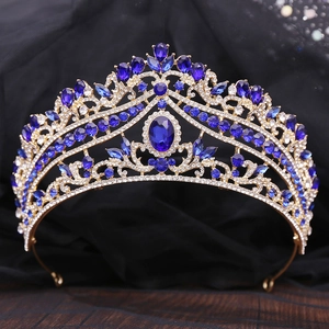 Detail of golden bridal crown featuring deep blue gemstones and sparkling crystals