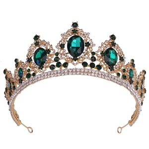 Detailed macro view of vintage gold alloy tiara with green rhinestones and intricate patterns