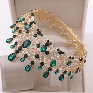 Détail de la couronne baroque dorée ornée de cristaux vert émeraude et de strass brillants