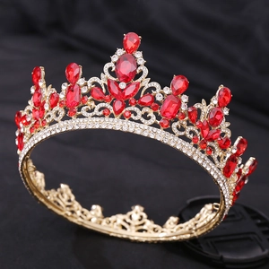 Close-up of red teardrop crystals and clear rhinestones on luxury gold crown