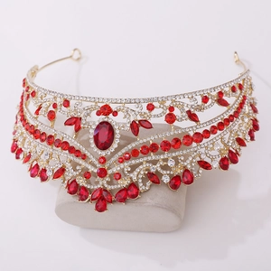 Detailed view of luxury gold alloy bridal crown with vibrant red crystals and intricate hollow patterns