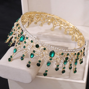 Détail d'une couronne de mariée dorée avec cristaux verts et strass blancs brillants