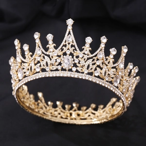 Gros plan d'une couronne de mariée baroque dorée avec motifs de feuilles en cristal