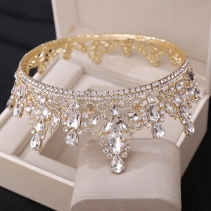 Close-up of golden crown with teardrop crystals and white rhinestones on display