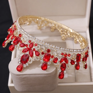 Macro detail of luxury baroque tiara featuring red crystal gems and golden filigree