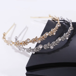 Dettaglio di eleganti cerchietti a foglia oro e argento con strass scintillanti